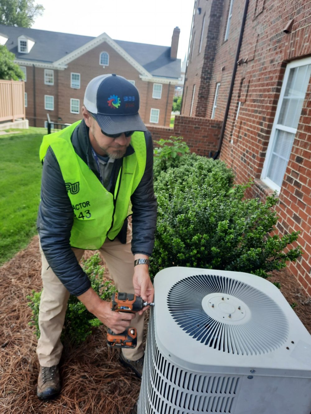 SBS-NC technician performing preventative maintenance on an AC condenser unit